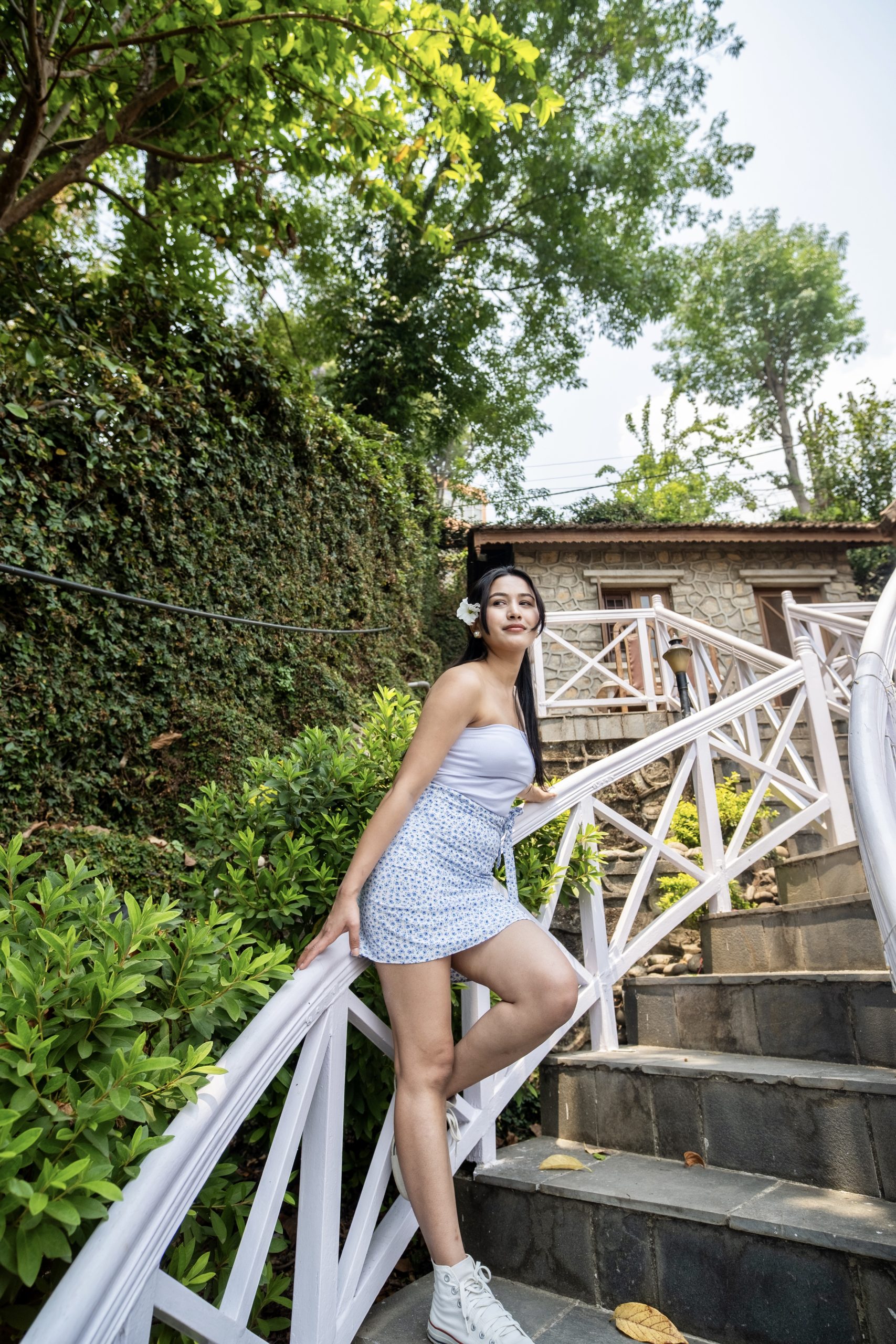 roshani shrestha standing in stairs holding railing with white summer clothes for girls dress
